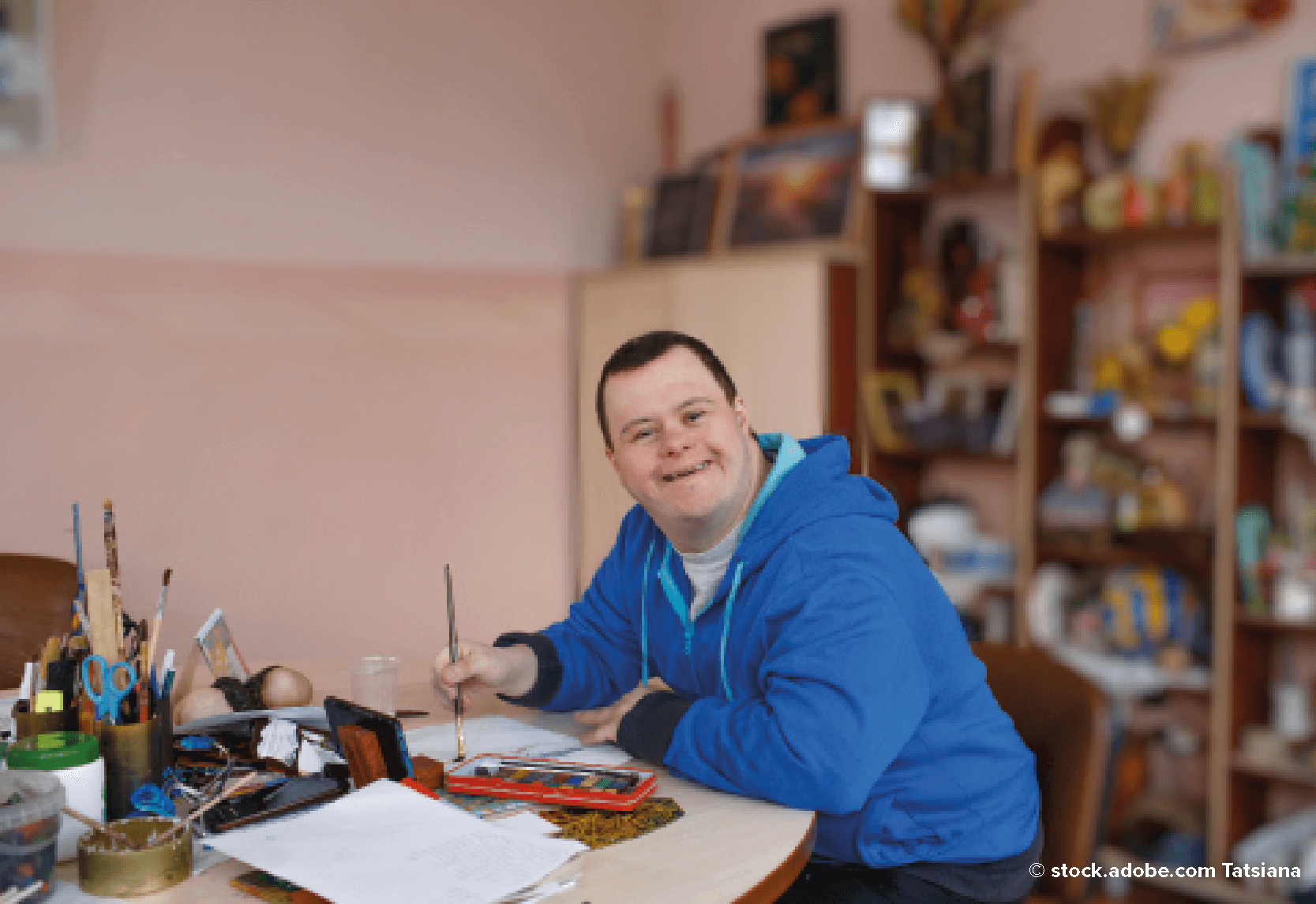 A boy in a blue hoody painting